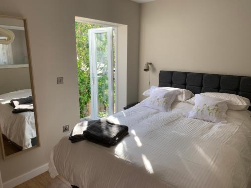 a bedroom with a large bed with a mirror at Lovely flat, balcony & woodstove, parking close in St. Agnes