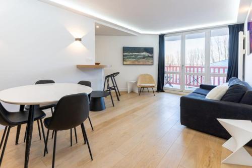 ein Wohnzimmer mit einem Tisch und einem Sofa in der Unterkunft Beautiful flat with swimming pool tennis court and private car parking REF 148 in Le Touquet-Paris-Plage