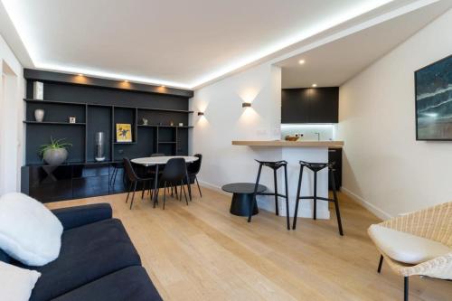 ein Wohnzimmer und eine Küche mit einem Sofa und einem Tisch in der Unterkunft Beautiful flat with swimming pool tennis court and private car parking REF 148 in Le Touquet-Paris-Plage