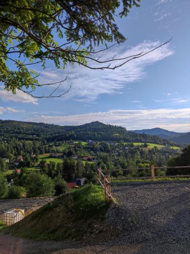 a view of a valley from a hill with a fence at Domki Wichrowe Wzgórze in Wisła