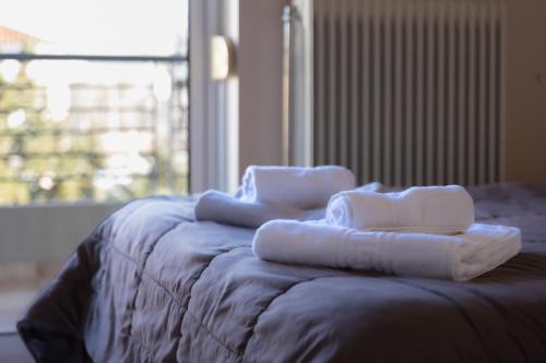 a bed with towels sitting on top of it at Central apartment with parking in Larisa