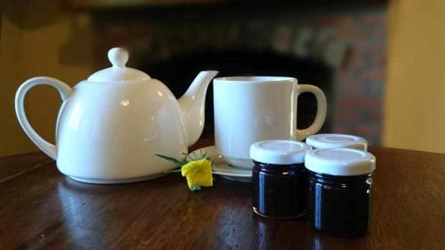 une bouilloire et deux pots de confiture sur une table dans l'établissement Agriturismo Al Pagan, à Pigna