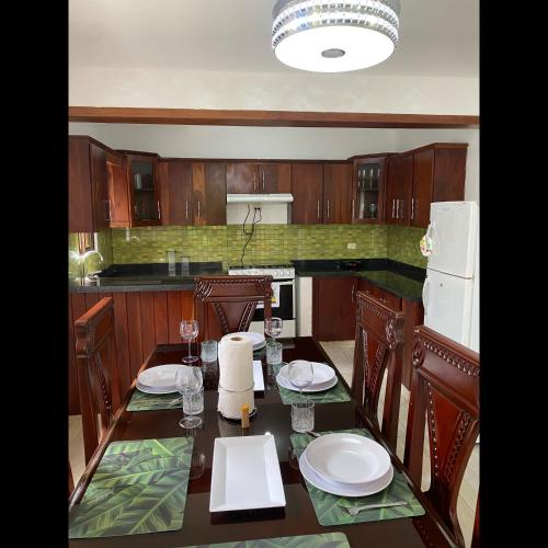 a kitchen with a table with chairs and a refrigerator at Apartment center of puerto plata in San Felipe de Puerto Plata