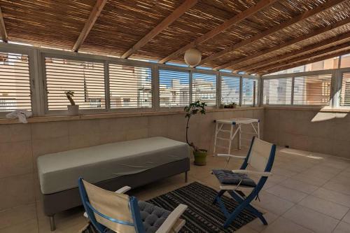 a room with a bed and two chairs and a table at rooftop studio 70 meters in Netanya
