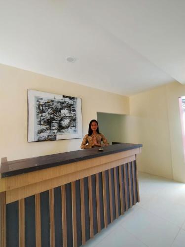 a woman sitting at a counter in a room at Spazio Hotel in Karimunjawa