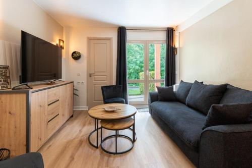 un salon avec un canapé et une table dans l'établissement Beautiful flat with swimming pool tennis court and private car parking 09, à Le Touquet-Paris-Plage