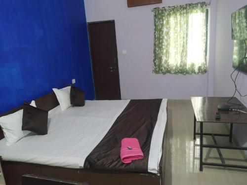 ボーパールにあるHotel sambhodhi palaceのピンクの袋が部屋のベッドに座っています。