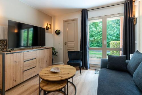 un salon avec un canapé et une table dans l'établissement Beautiful flat with swimming pool tennis court and private car parking 09, à Le Touquet-Paris-Plage