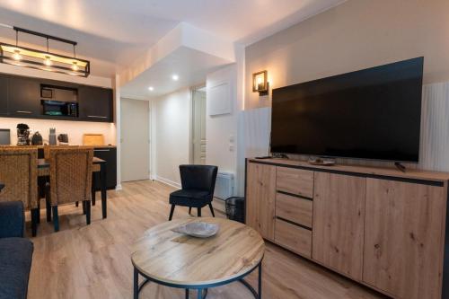 un salon avec une grande télévision à écran plat dans l'établissement Beautiful flat with swimming pool tennis court and private car parking 09, à Le Touquet-Paris-Plage