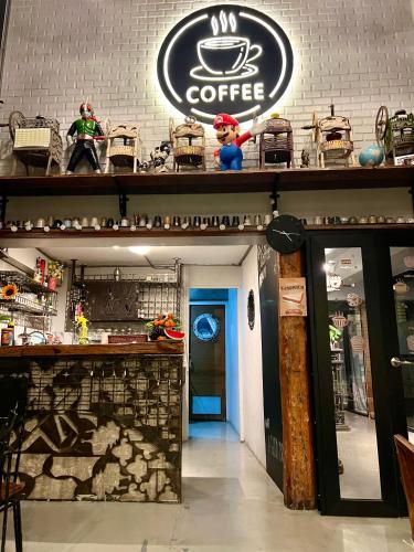a coffee shop with a sign on the wall at Eachother Hostel in Chiang Mai