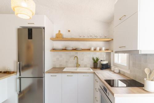 a white kitchen with a sink and a refrigerator at Sani Bliss by halu!, 2-BD villa with private garden in Sani Beach