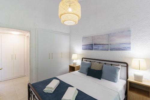 a bedroom with a large bed with blue pillows at Sani Bliss by halu!, 2-BD villa with private garden in Sani Beach