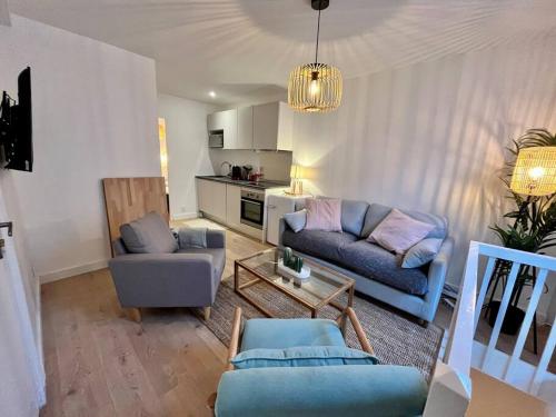 un salon avec deux canapés et une cuisine dans l'établissement T3 rénové entre gare et Nansouty, à Bordeaux