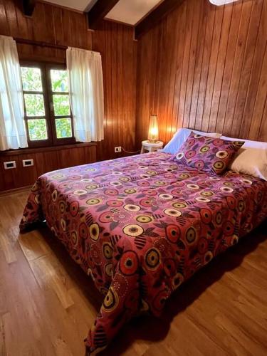 ein Schlafzimmer mit einem Bett mit einer farbenfrohen Tagesdecke in der Unterkunft Departamento Del Centro Primer Piso in El Bolsón