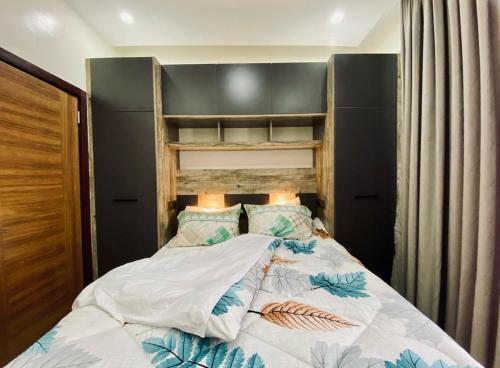 a bedroom with a bed with a wooden headboard at LUXURYSTAY-CATION in Kigali