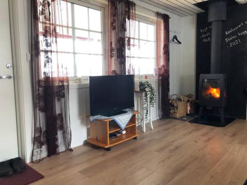 a living room with a flat screen tv and a fireplace at Nyrestaurert og koselig hytte ved Skjelbredvatnet. in Sandvika