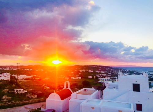 a sunset over a city with white buildings at Villa Vasilis in Mýkonos City
