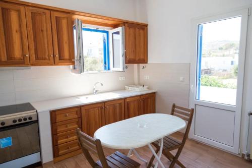 a kitchen with a table and a sink and a window at Villa Vasilis in Mýkonos City