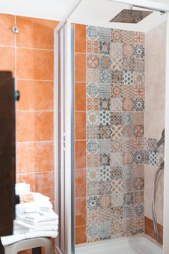 a shower in a bathroom with a tile wall at Agriturismo Irghitula in Posada
