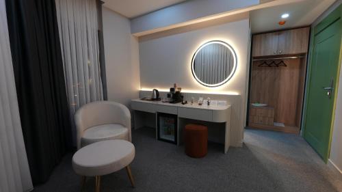 a bathroom with a sink and a mirror and a chair at CARTİER LUXURY OTEL in Diyarbakır