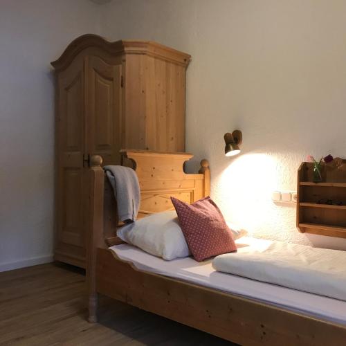 a bedroom with a bed with a wooden headboard at Gästehaus Hotel Maria Theresia in Schliersee