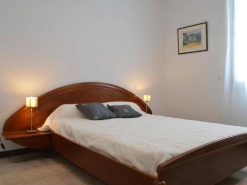 a bedroom with a wooden bed with two blue pillows at Appartement Banyuls-sur-Mer, 3 pièces, 5 personnes - FR-1-225C-39 in Banyuls-sur-Mer