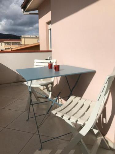 a blue table and a white chair on a roof at Comfort Home in Capoterra