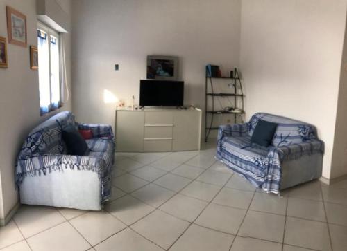 sala de estar con 2 sillas y TV en Comfort Home, en Capoterra