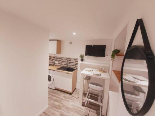 une cuisine blanche avec un évier et une cuisinière four supérieur dans l'établissement Duplex Cosy 2, à Gouesnou