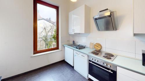 una cocina con electrodomésticos blancos y una ventana en Handwerker Domizil Walle, en Bremen