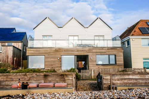 a house on the beach with a fence at Twitterings - West Wittering in Chichester