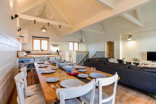 a dining room with a table and a couch at Twitterings - West Wittering in Chichester