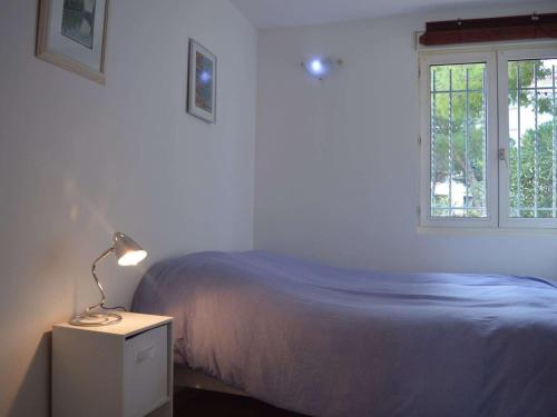 - une chambre avec un lit et une lampe sur une table de chevet dans l'établissement Spacieux T3 à Banyuls-sur-Mer, 6 couchages, proche mer, parking, lave-vaisselle, TV, ménage inclus - FR-1-225C-52, à Banyuls-sur-Mer