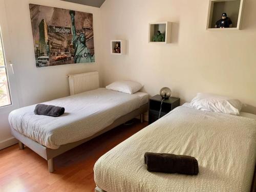 une chambre avec deux lits et un tableau au mur dans l'établissement Superbe appartement proche Disney, à Bussy-Saint-Georges