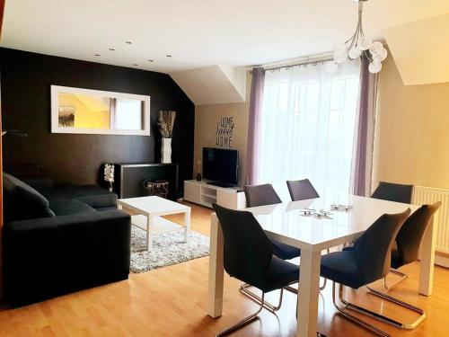 un salon avec une table et des chaises blanches dans l'établissement Superbe appartement proche Disney, à Bussy-Saint-Georges