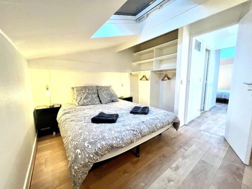 - une chambre avec un lit et 2 serviettes noires dans l'établissement Cosy T3 proche gare et Nansouty, à Bordeaux