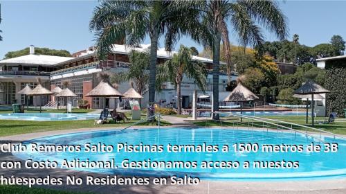 - un bâtiment avec une piscine et des palmiers dans l'établissement 3B Habitación Norte Single con Baño compartido al fondo, à Salto