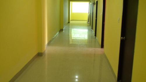 an empty hallway with yellow walls and a long floor at HOTEL GOLDEN BUDDHA INN in Bodh Gaya