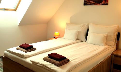 1 cama blanca grande con 2 toallas en Best Apartments Szeged, en Szeged
