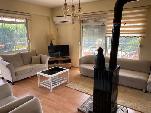 un soggiorno con due divani e un camino di ormanın içinde geniş havuzlu triplex villa a Manavgat