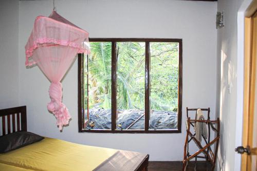a bedroom with a bed and a window at Seasons Four Jungle Treehouse in Matara