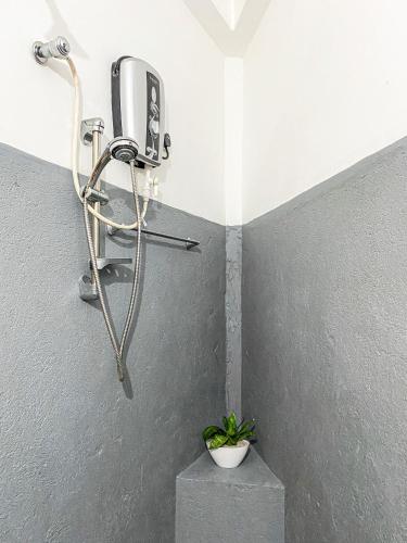 a shower with a phone and a plant in a room at Seasons Four Jungle Treehouse in Matara