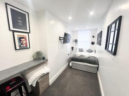 ein Schlafzimmer mit einem Bett in einem weißen Zimmer in der Unterkunft Cosy Flat by Anfield: 5 Minutes from the Stadium! in Liverpool