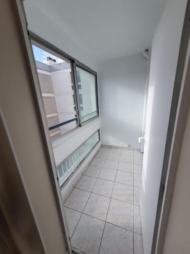 a hallway with a window and a tiled floor at APPARTEMENT ARENA/ GROUPAMA STADIUM/ EUREXPO in Décines-Charpieu