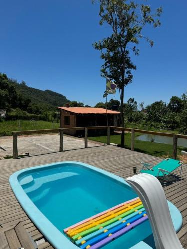 a swimming pool with a bench next to a house at Recanto Magnata 