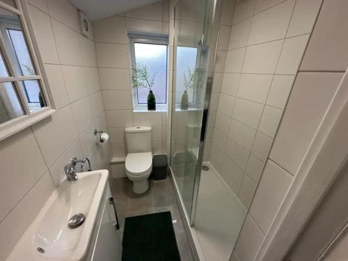 uma casa de banho com um chuveiro, um WC e um lavatório. em Blossom Holiday Lets - 3 Bed Bensham Apartment em Gateshead