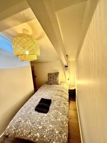 Cette petite chambre comprend un lit et une lampe. dans l'établissement T3 Duplex entre gare et Nansouty, à Bordeaux
