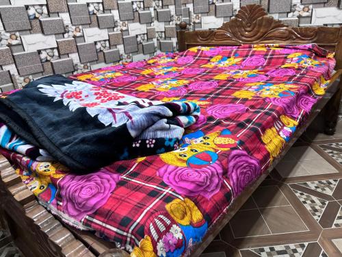 a bed with a colorful quilt on top of it at Sunrise Plaza ( ठहरने का उत्तम प्रबंध) in Deoghar