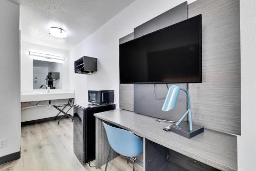 a room with a desk with a flat screen tv at Motel 6-Austin, TX - Airport - South in Austin