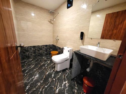 a bathroom with a white toilet and a sink at Rashiva Resort in Arambol